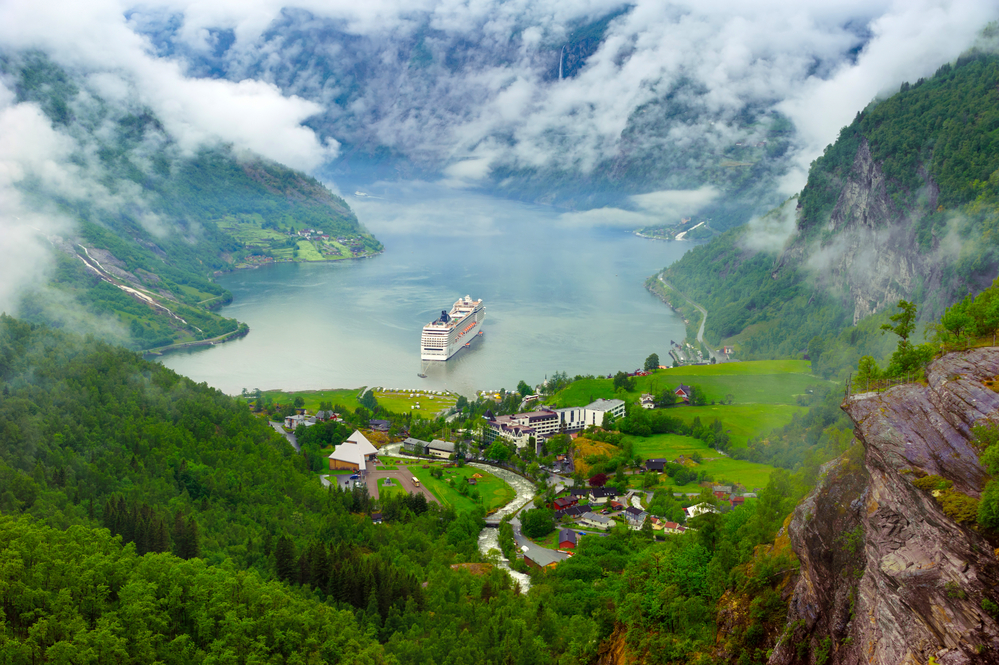 Norway cruise ship leaving a mountainous village port